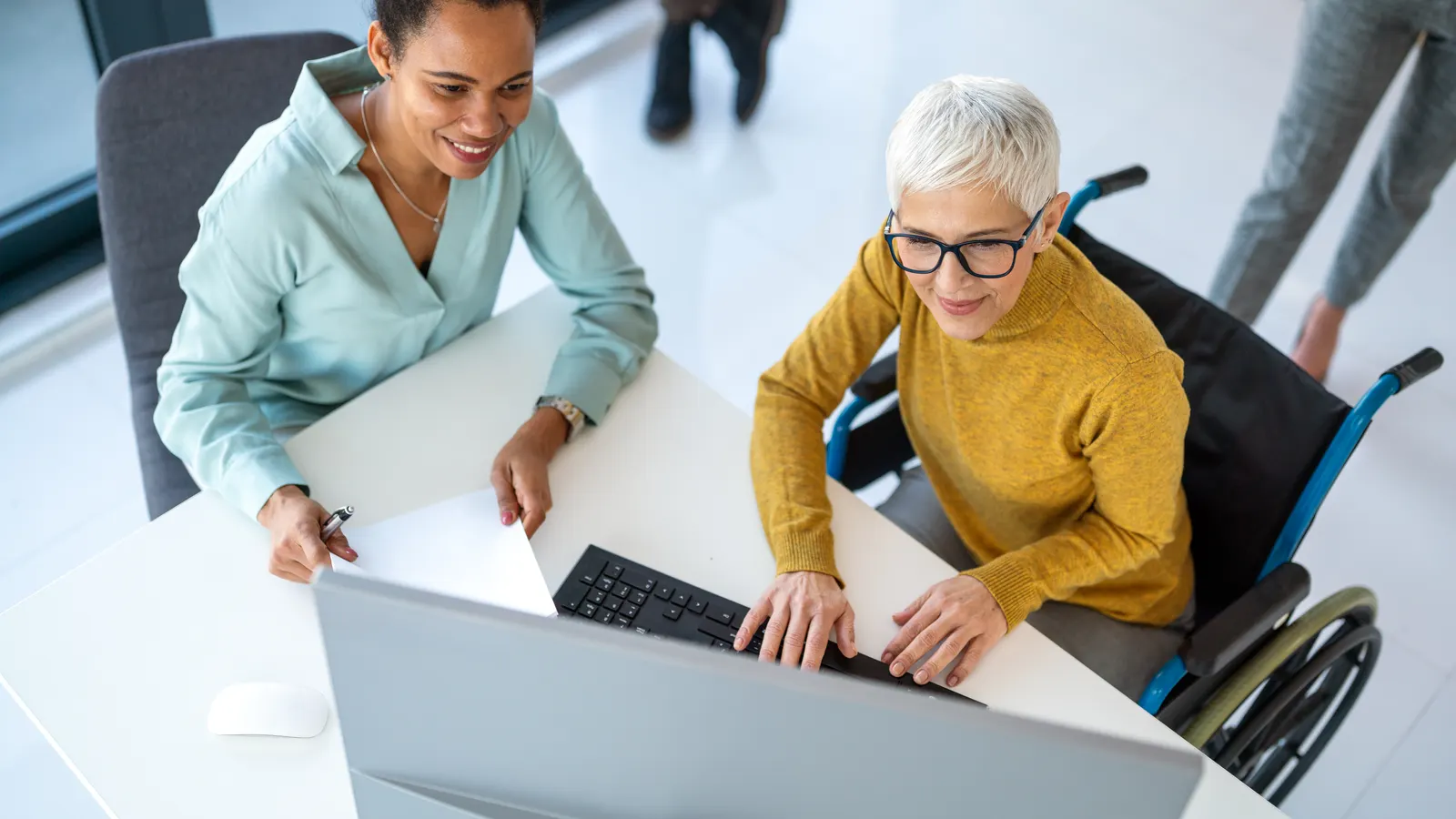 Two colleagues looking at a computer together in an office