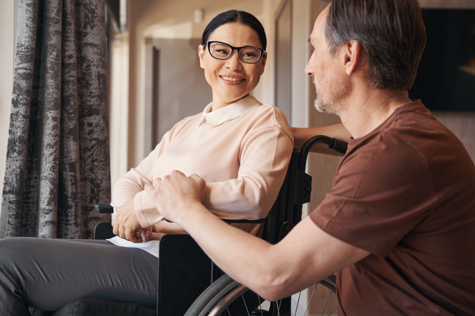 A woman using a wheelchair talking with a friend outdoors