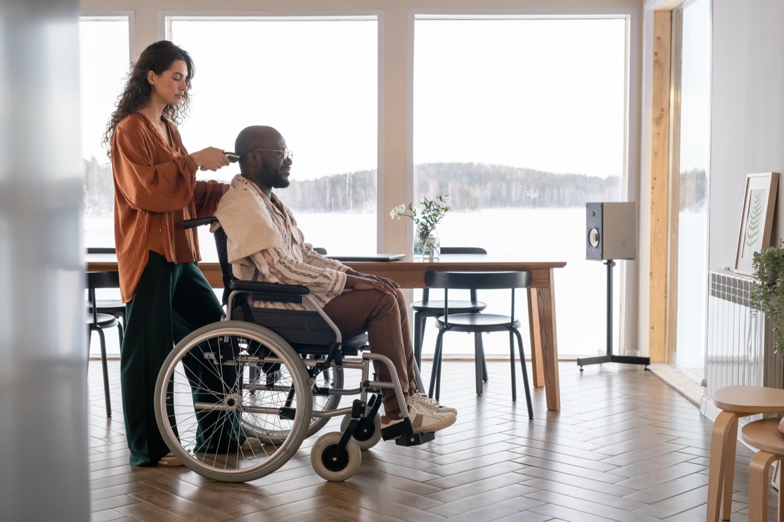 A support worker assisting a man in a wheelchair at home
